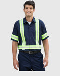 A man wearing a navy blue short-sleeve work shirt with high-visibility neon yellow-green reflective stripes, paired with navy pants and a black belt, against a light gray background.