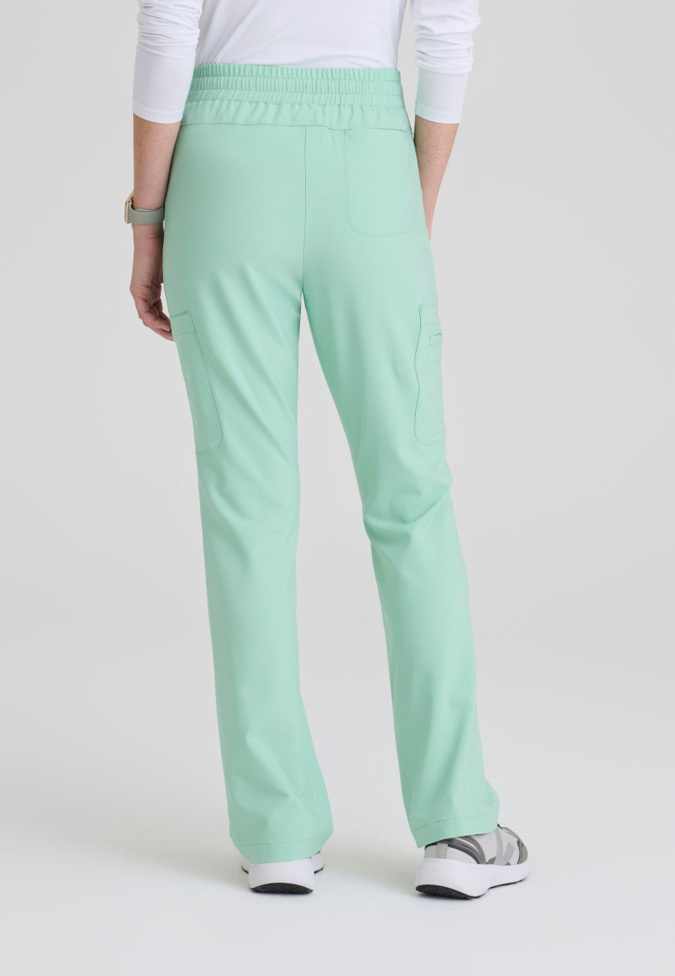 Back view of the GSSP729 Grey's Anatomy Evolve Sky Fit and Flare Scrub pant in the colour Soft Melon.