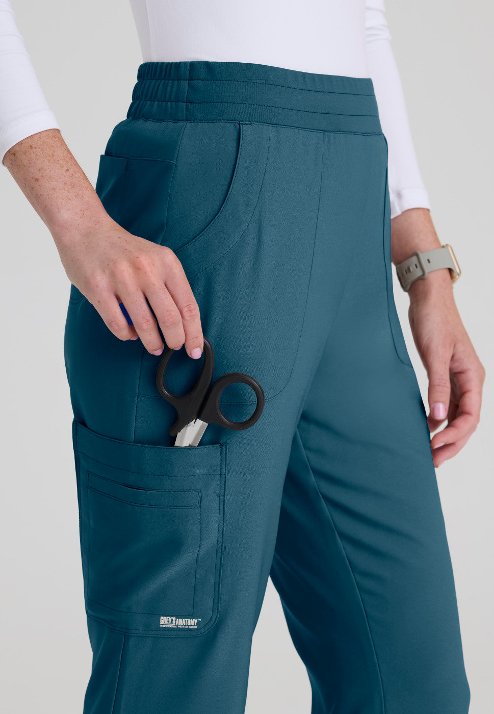 Close up  view of the GSSP729 Grey's Anatomy Evolve Sky Fit and Flare Scrub pant in the colour Bahama.