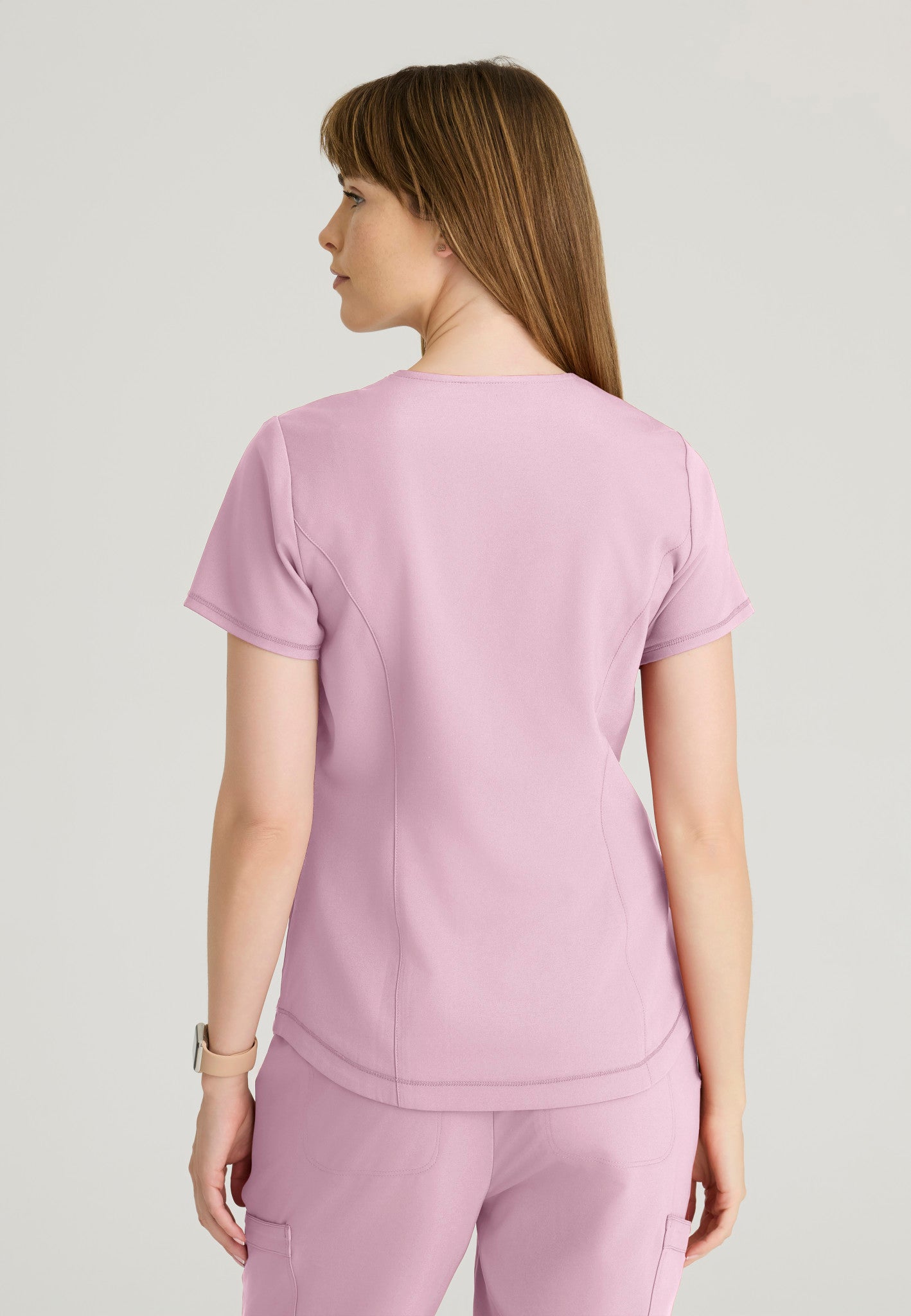 Back view of the Grey's Anatomy Evolve women's Rhythm scrub top in the colour Misty Pink.