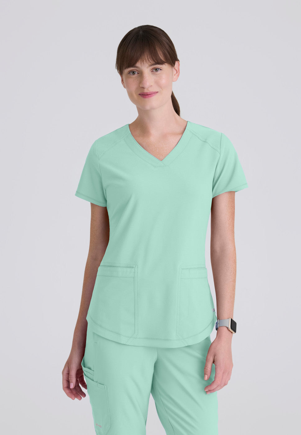 Front view of the GSST180 Grey's Anatomy Evolve Women's Scrub Top in the colour soft melon.