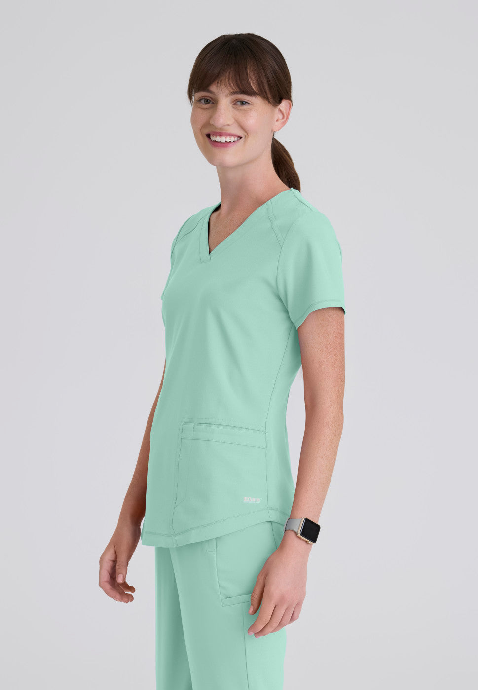 Side view of the GSST180 Grey's Anatomy Evolve Women's Scrub Top in the colour soft melon.
