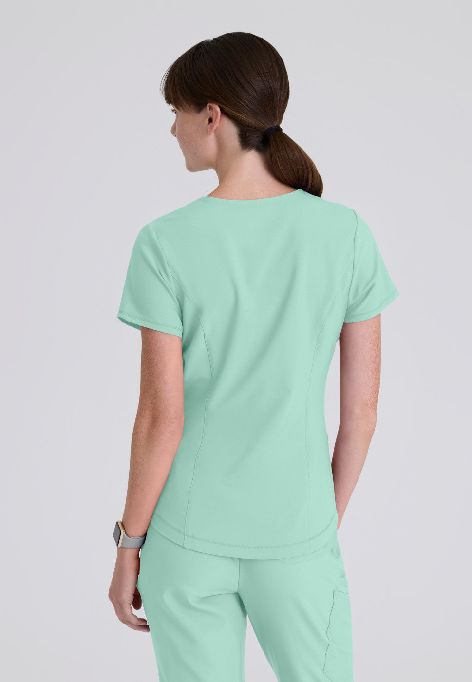 Back view of the GSST180 Grey's Anatomy Evolve Women's Scrub Top in the colour soft melon.