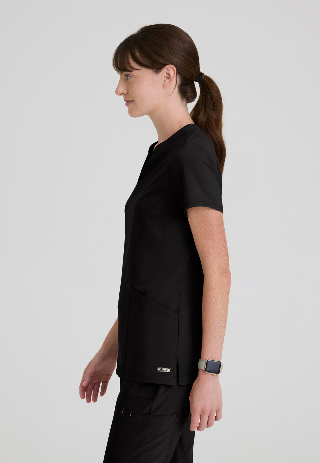 Side view of the Grey's Anatomy Evolve women's Sky scrub top in the colour Black.