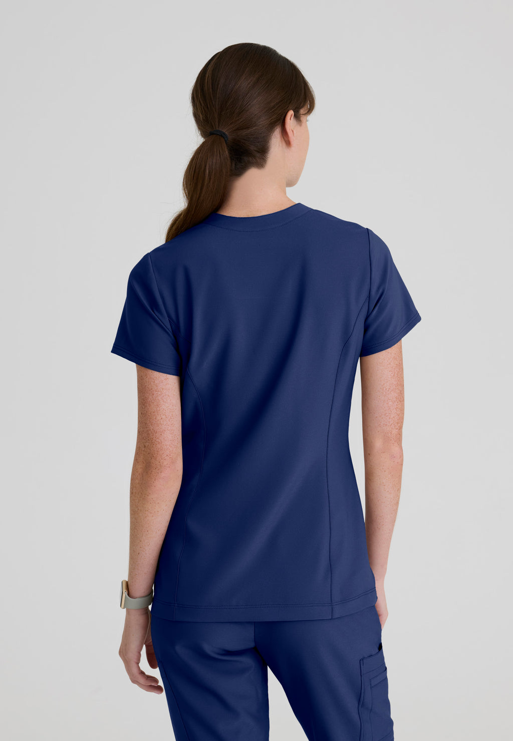 Back view of the Grey's Anatomy Evolve women's Sky scrub top in the colour Indigo.
