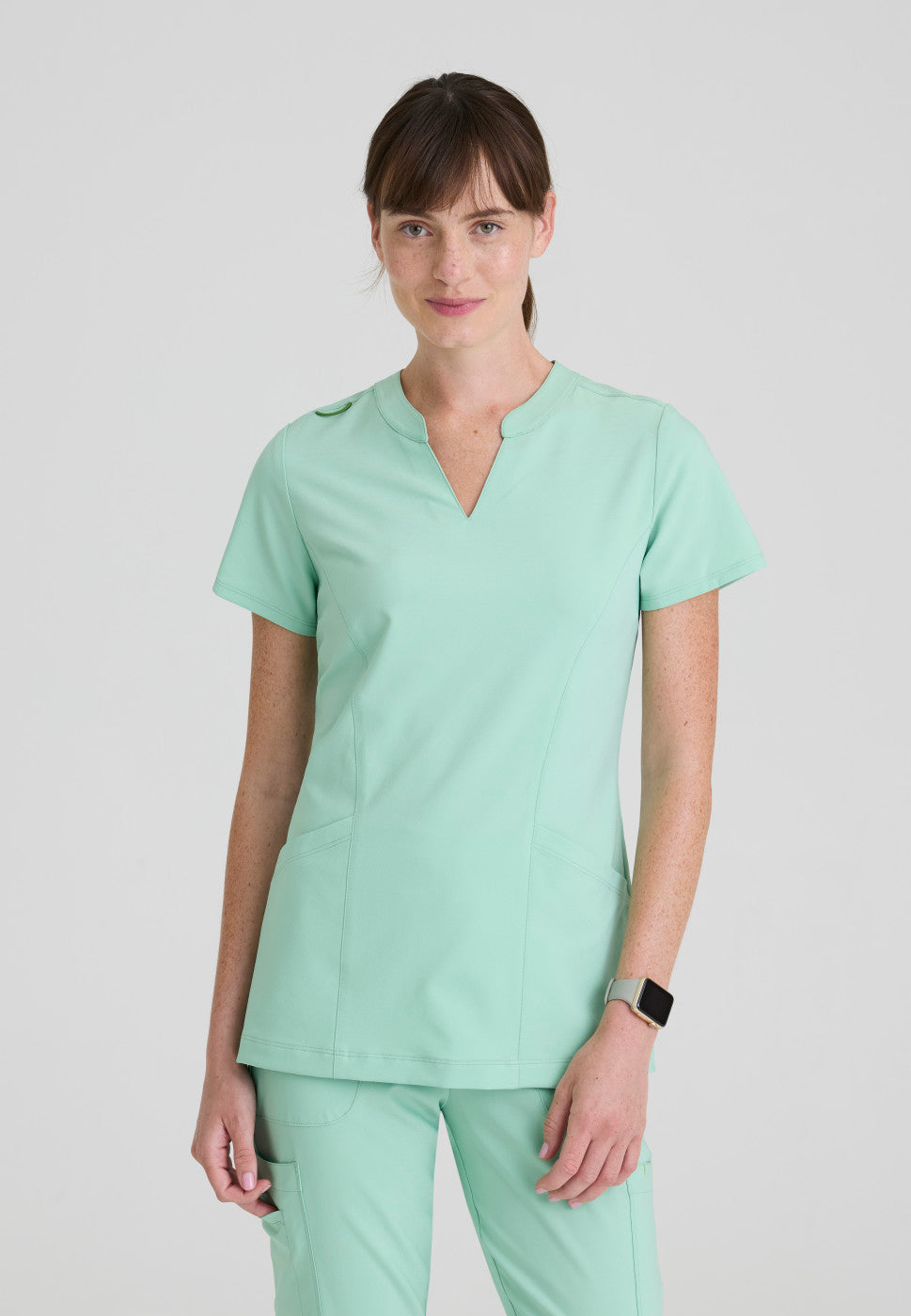 Front view of the GSST298 Grey's Anatomy Evolve Sky Banded Scrub Top in the colour Soft Melon.