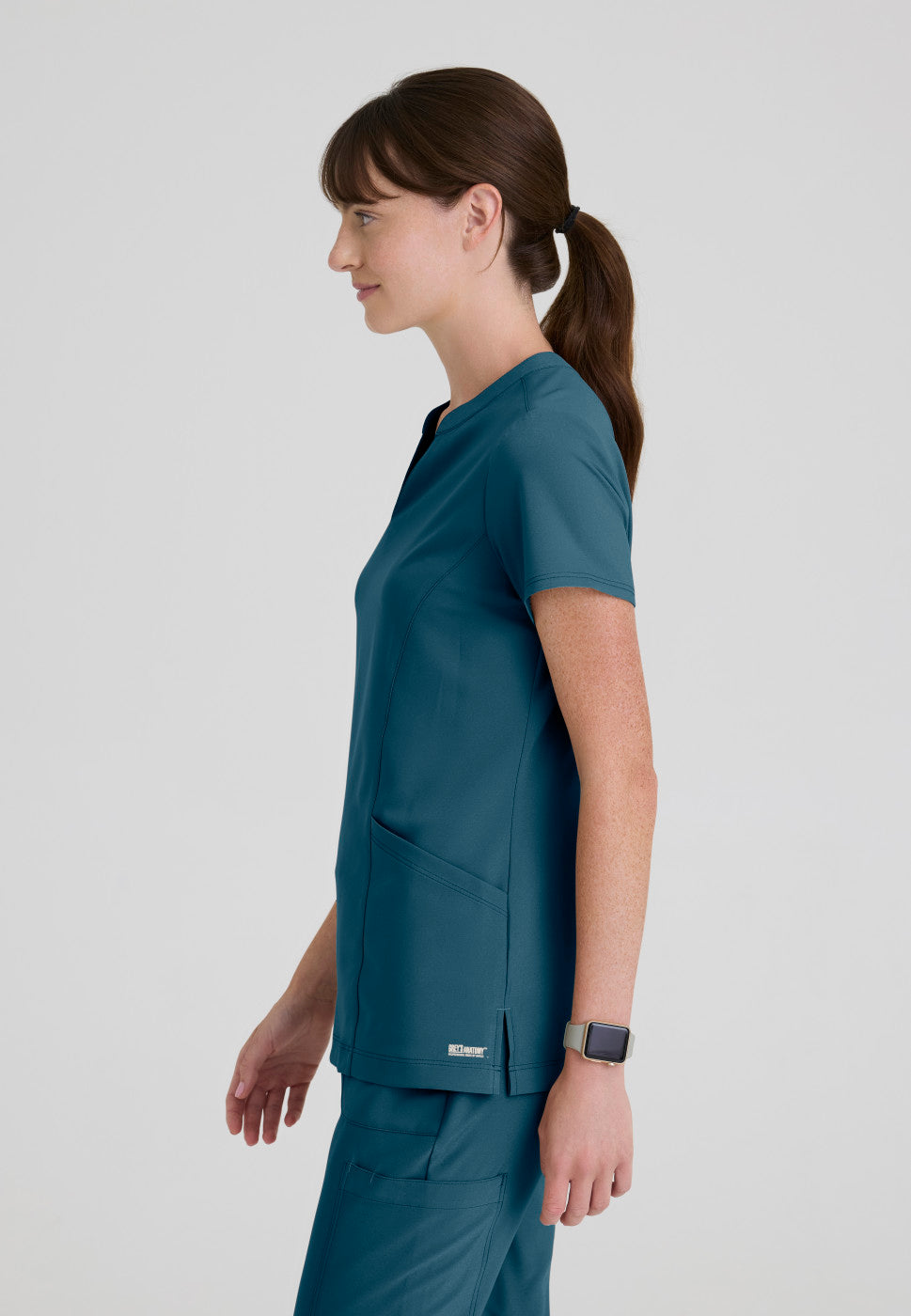 Side view of the GSST298 Grey's Anatomy Evolve Sky Banded Scrub Top in the colour Bahama.