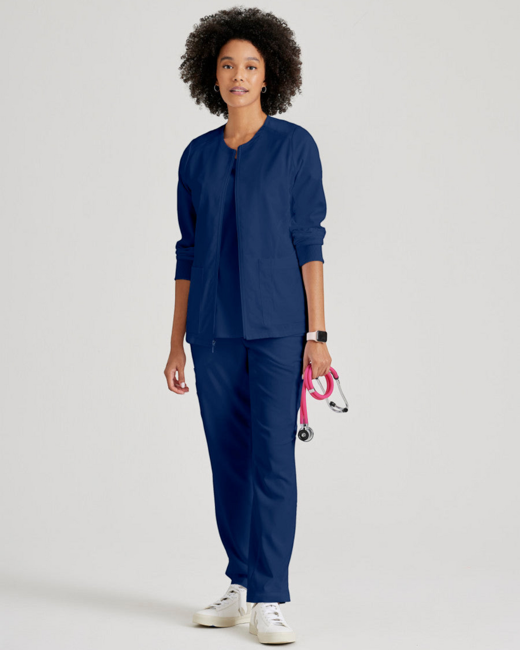 Lasalle Uniform Gianna warm-up scrub jacket in navy blue with a zip-front, worn by a model with a stethoscope.