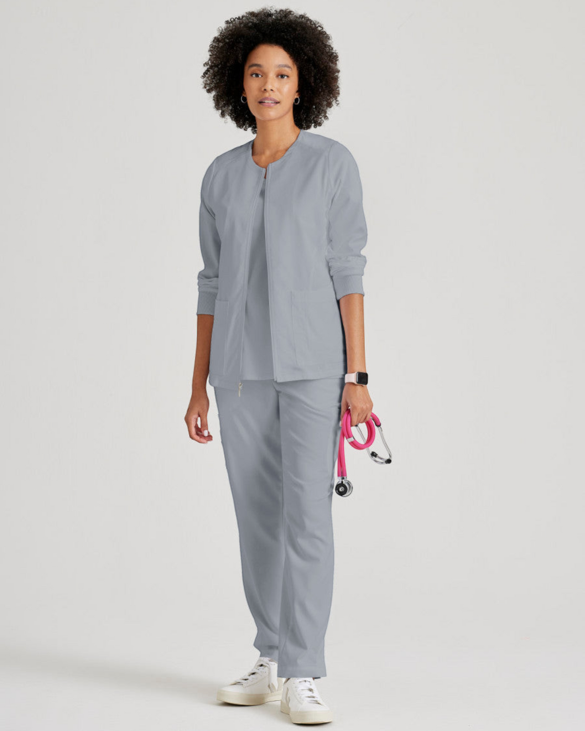 Lasalle Uniform Gianna warm-up scrub jacket in grey with a round neck, zip front, and rib-knit cuffs on a model.