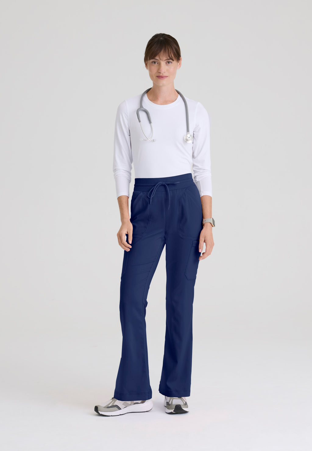 Full view of Kristi women's high-rise scrub pant featuring a fit & flare leg, knit waistband, and 7-pocket design. Indigo colour.