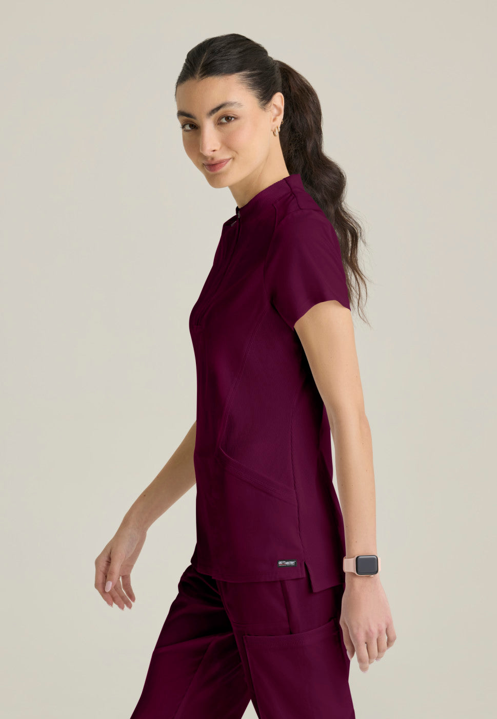 Side view of the GRST292 Women's Grey's Anatomy Kristi Scrub Top in the colour WINE.