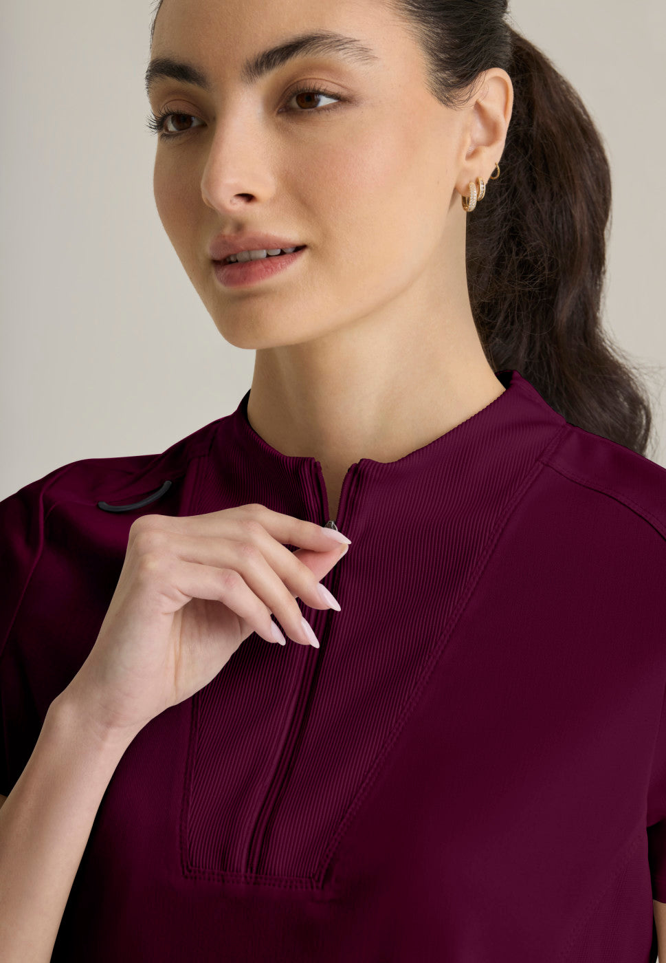 Close up view of the GRST292 Women's Grey's Anatomy Kristi Scrub Top in the colour WINE.
