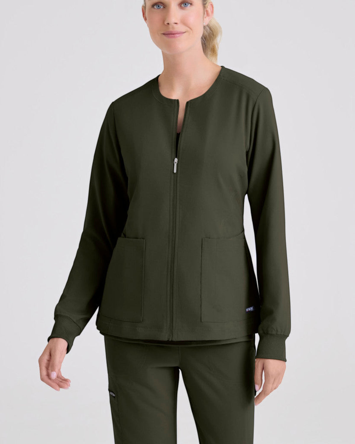 Lasalle Uniform Gianna warm-up scrub jacket in olive green with a full zip front, round neck, and rib-knit cuffs.