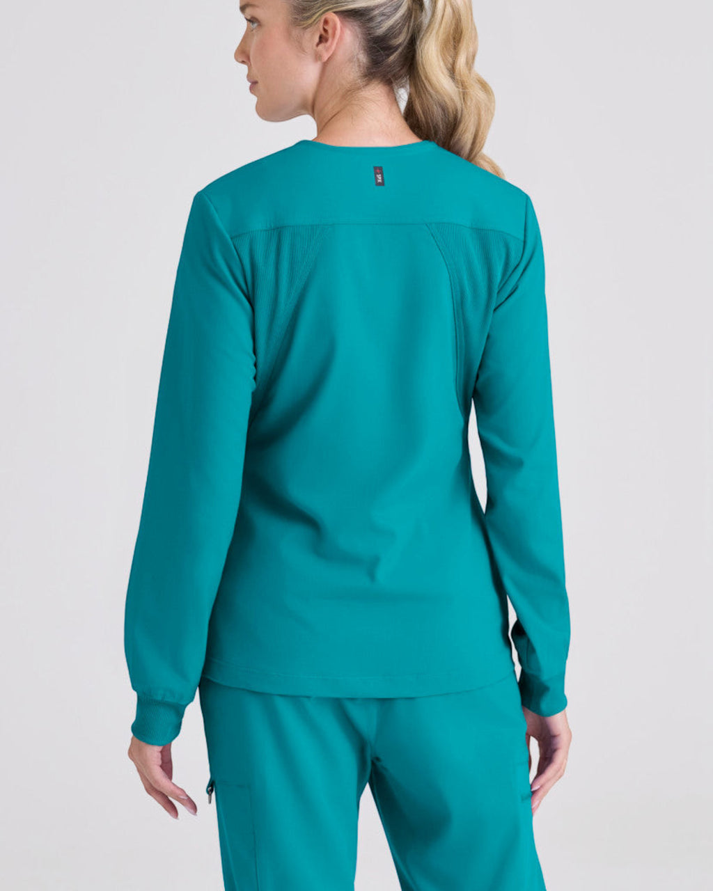 Lasalle Uniform Gianna warm-up scrub jacket in teal with long sleeves, rib-knit cuffs, and a round neckline.