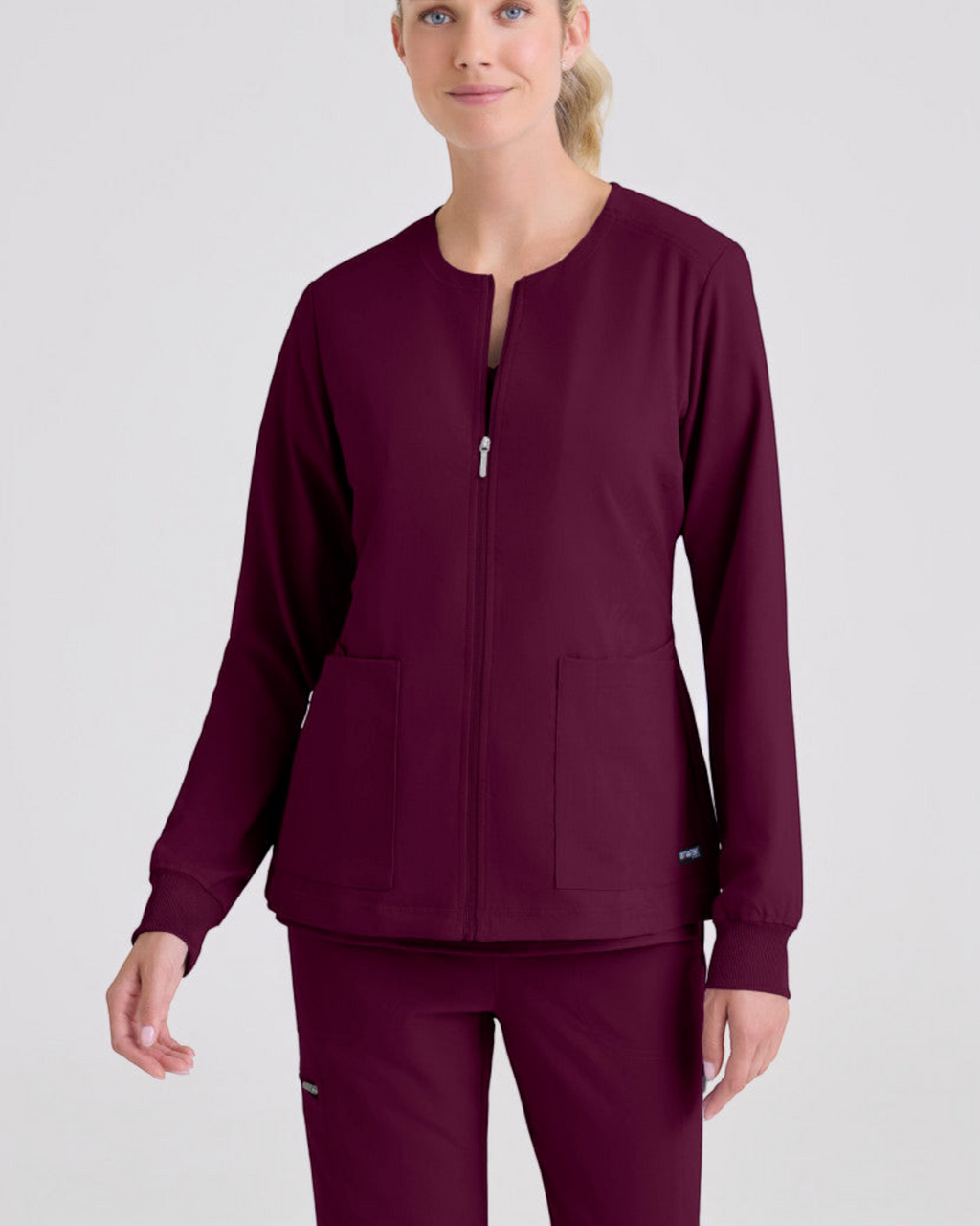 Lasalle Uniform Gianna warm-up scrub jacket in deep burgundy with a zip-front, round neck, and rib-knit cuffs.