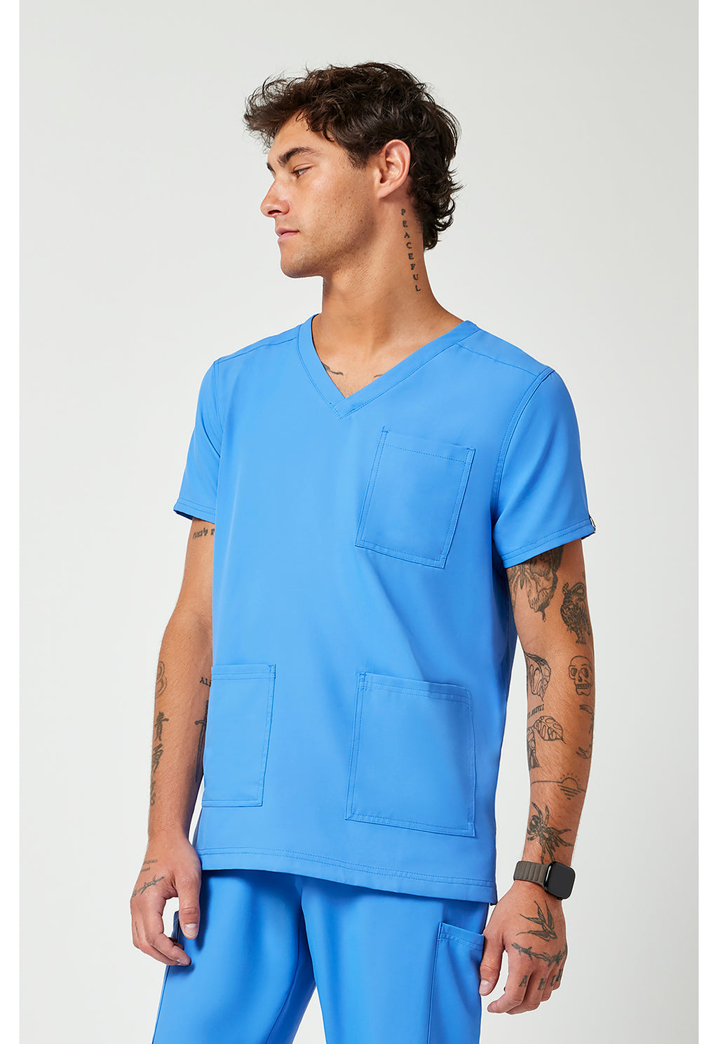 Side view of the Med Couture Rothwear Insight Men's 3-Pocket Scrub Top MC2486 in the colour ceil blue.
