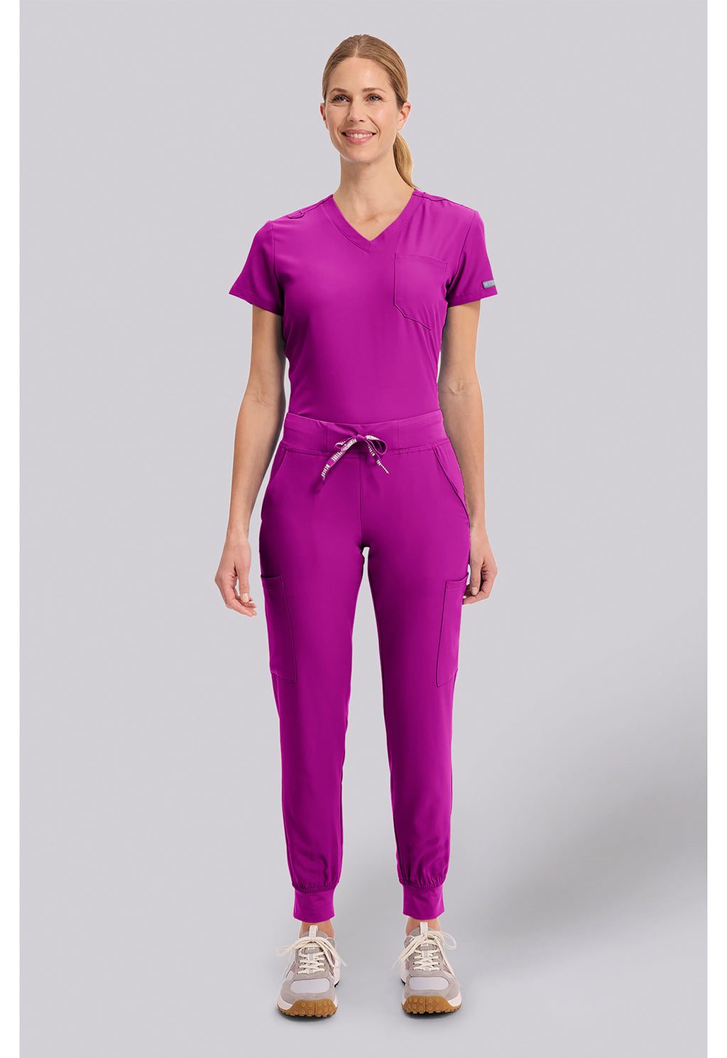 Insight 6-Pocket Scrub Jogger in magenta worn by a model with a drawstring waist and jogger cuffs by MED COUTURE Insight for Med Couture Scrubs