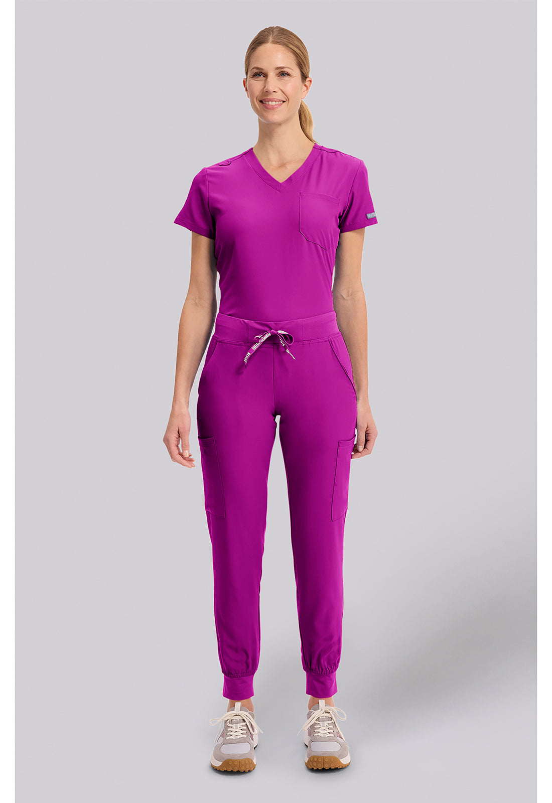 Insight 6-Pocket Scrub Jogger in magenta worn by a model with a drawstring waist and jogger cuffs by MED COUTURE Insight for Med Couture Scrubs