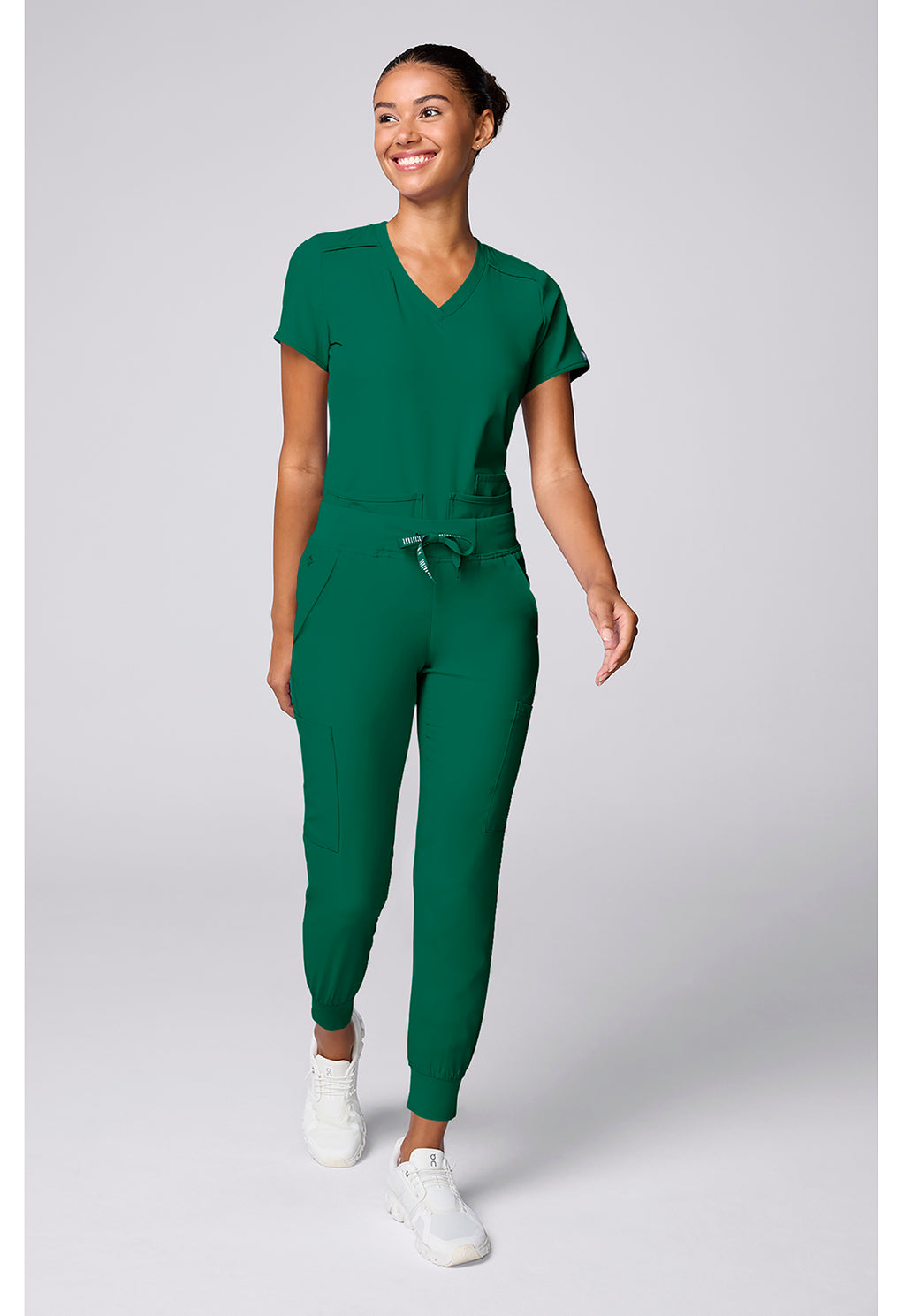 Insight 6-Pocket Scrub Jogger in green worn by a woman with MED COUTURE Insight athletic fit and tapered leg workwear