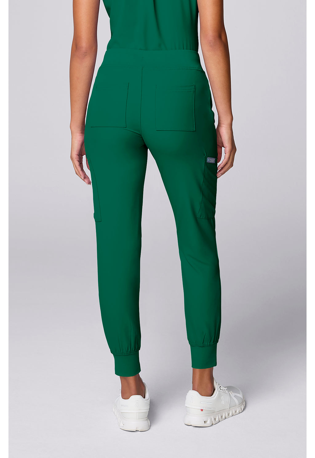Insight 6-Pocket Scrub Jogger in green shown from the back on a model with elastic cuffs and multiple pockets by MED COUTURE Insight
