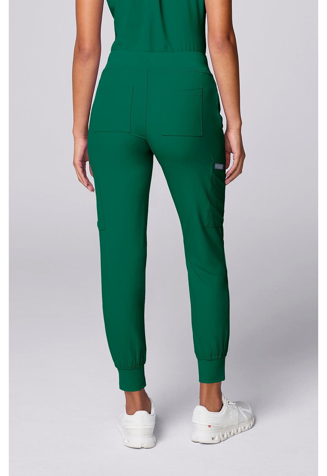 Insight 6-Pocket Scrub Jogger in green shown from the back on a model with elastic cuffs and multiple pockets by MED COUTURE Insight