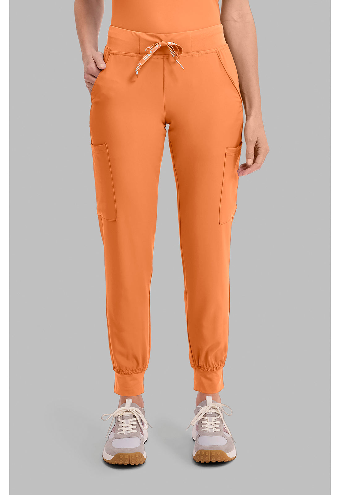 Insight 6-Pocket Scrub Jogger in orange with six pockets drawstring waist and elastic cuffs shown with sneakers by MED COUTURE Insight for scrub workwear