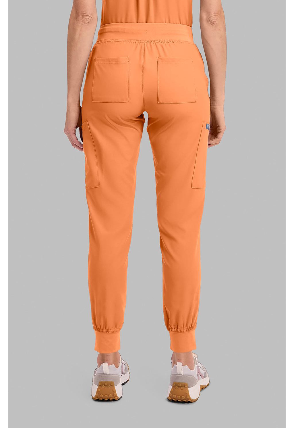Insight 6-Pocket Scrub Jogger in orange shown from the back with elastic cuffs and multiple utility pockets from MED COUTURE Insight