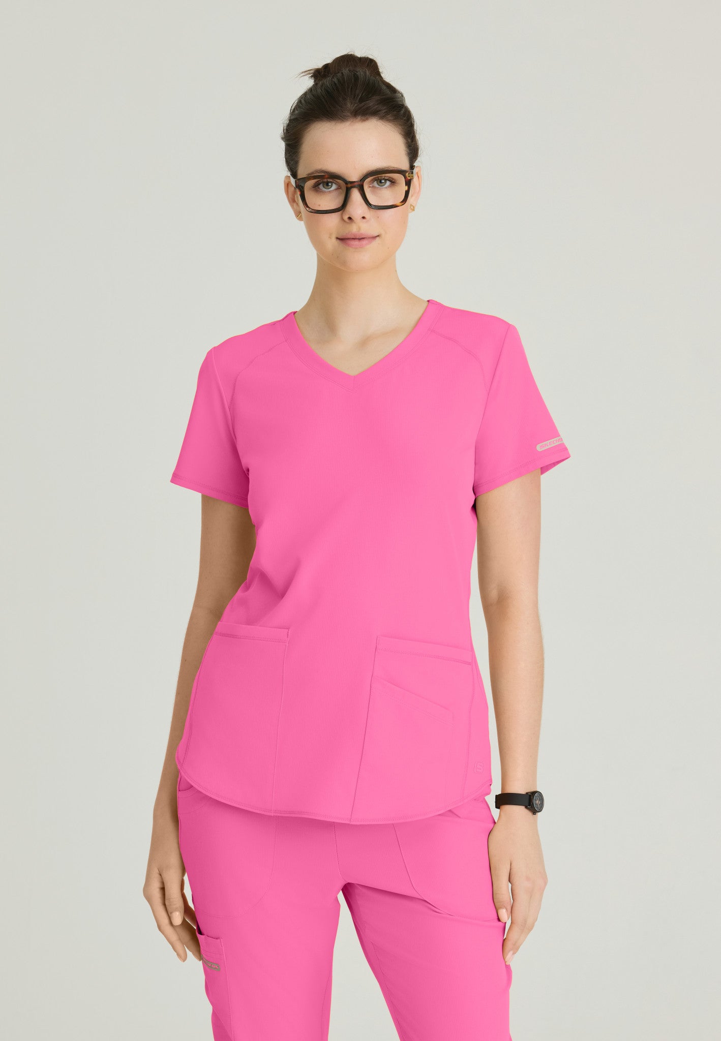 Front view Skechers Women's Breeze scrub top in the colour Passion Pink.