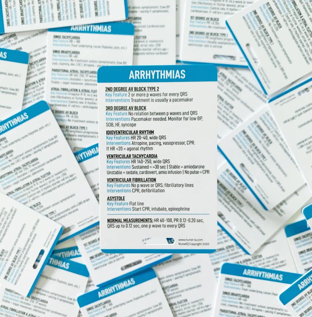 A close-up of printed arrhythmia reference cards spread out, showing blue headers with white text detailing rhythm patterns and diagnostic criteria.